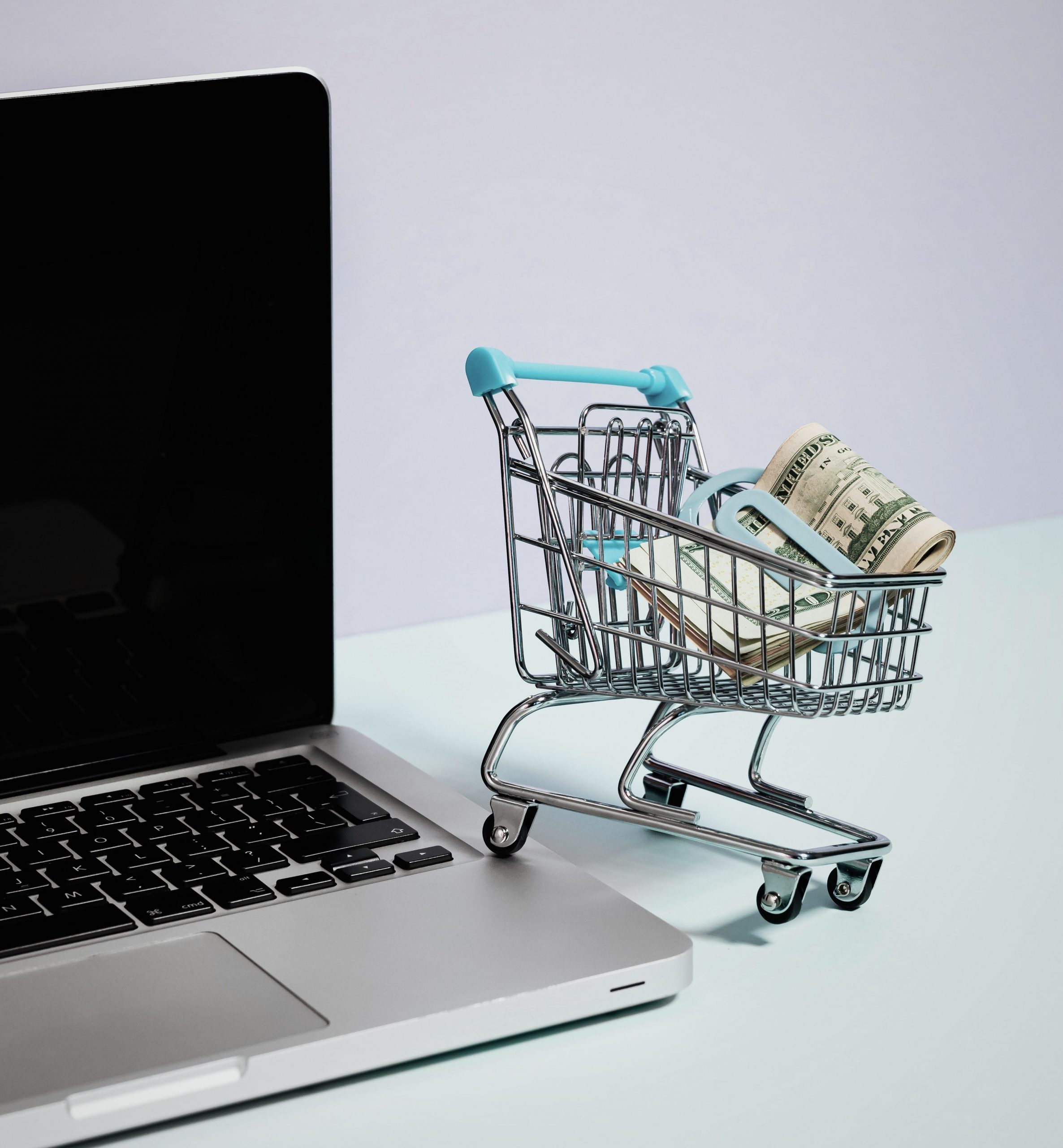 A laptop and and a mini-basket with money